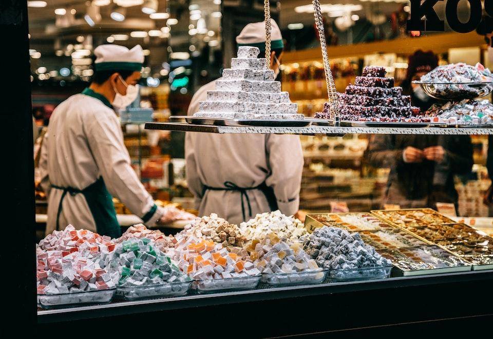 A shop seen from outside, confections are piled attractively in the window