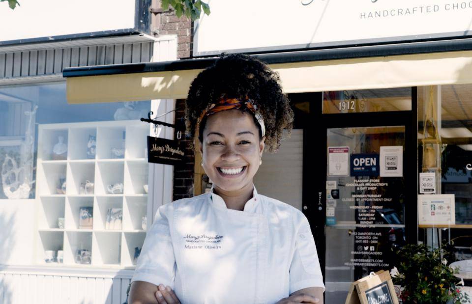 Mariane Oliveira standing outside her shop