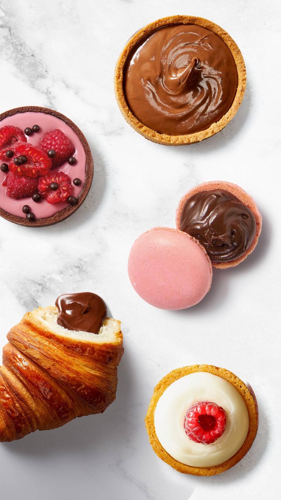 A variety of filled bakery products: croissants, tarts, macarons