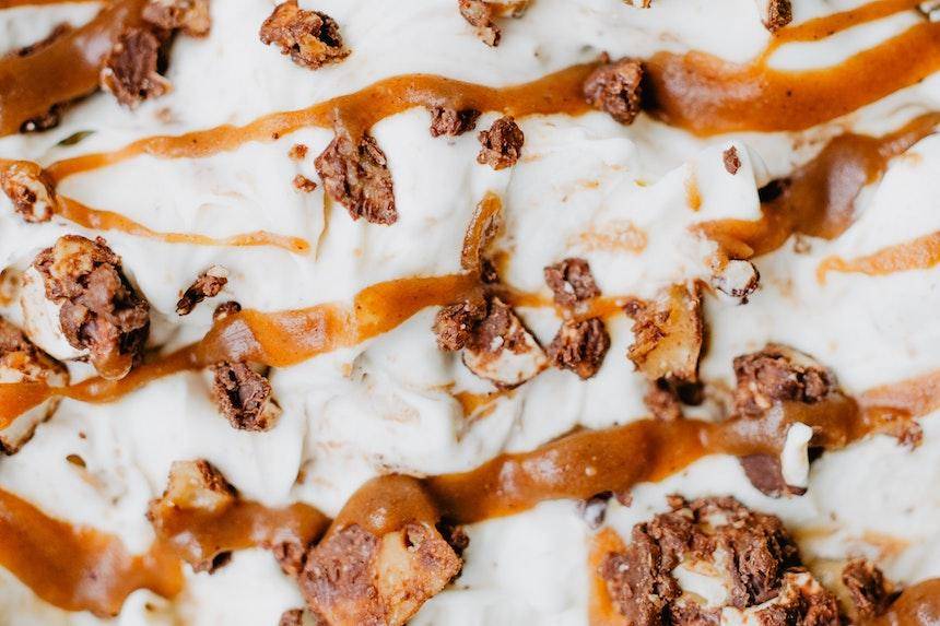white chocolate sprinkled with nuts and drizzled with caramel