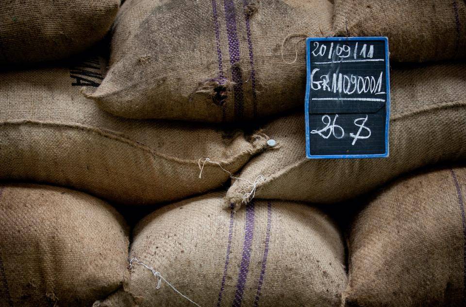 Stacks of burlap sacks with a chalk sign with date and origin information