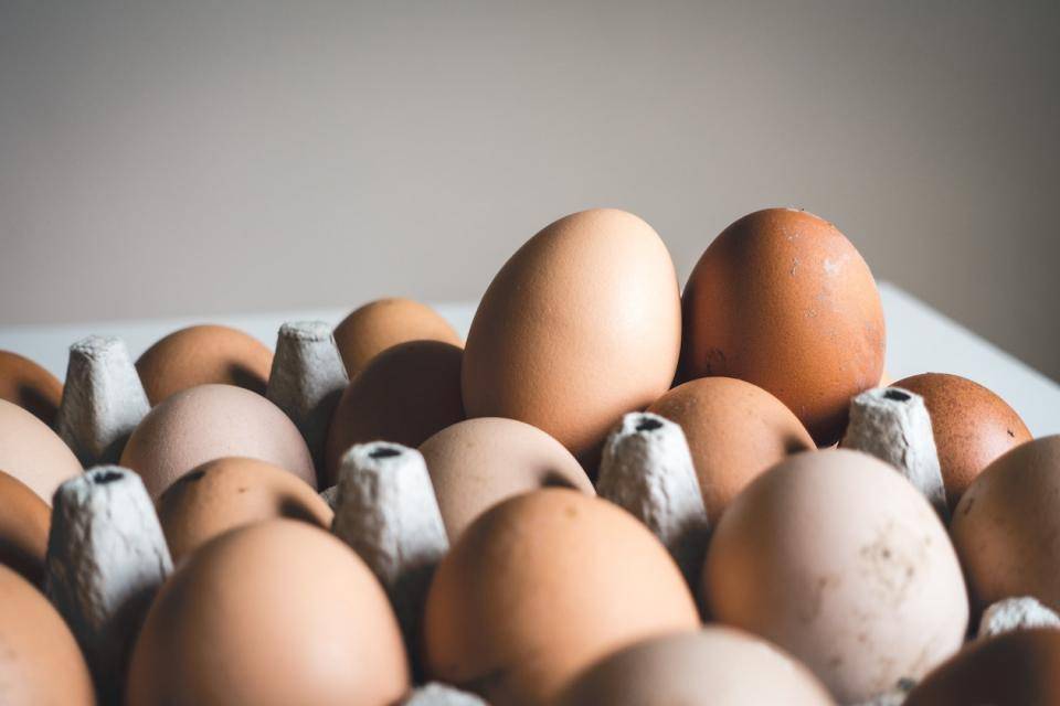 Eggs in varying shades of brown in a cardboard flat