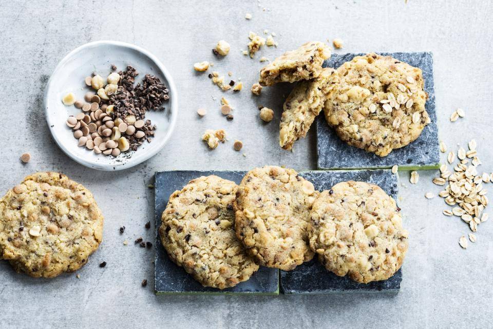 Cookies on tabletop with oats and cacao nibs scattered around