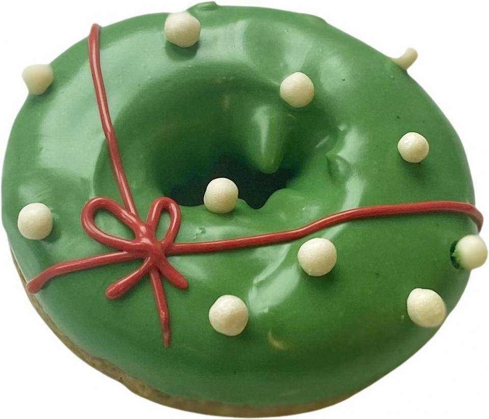 A festive donut glazed in green and garnished with white Crispearls™ and an icing bow