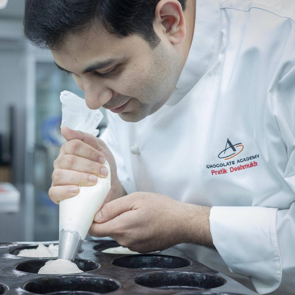 Chef Pratik Deshmukh pipes batter into molds