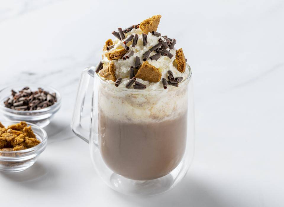 Indulgent hot chocolate garnished with whipped cream, cookie bits, and chocolate curls