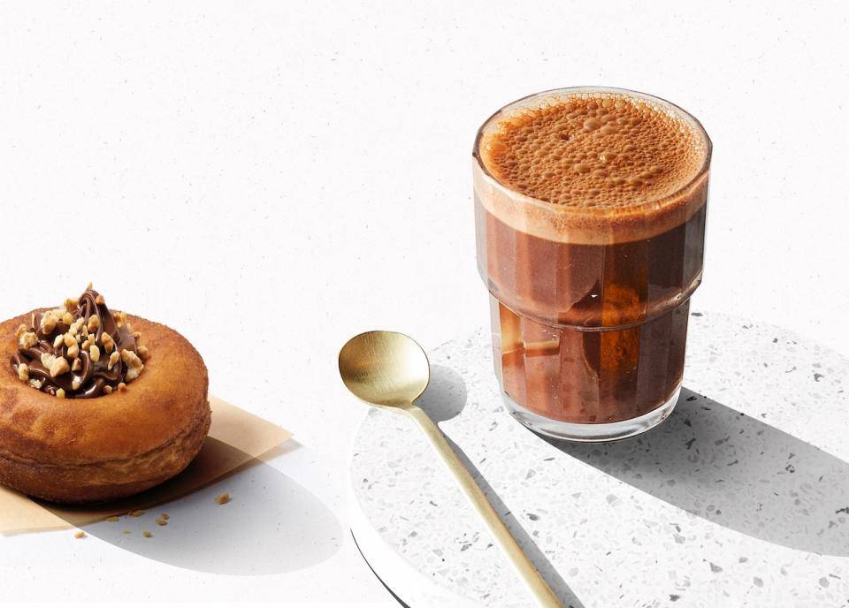 A frothy chocolate drink, spoon, and matching dessert