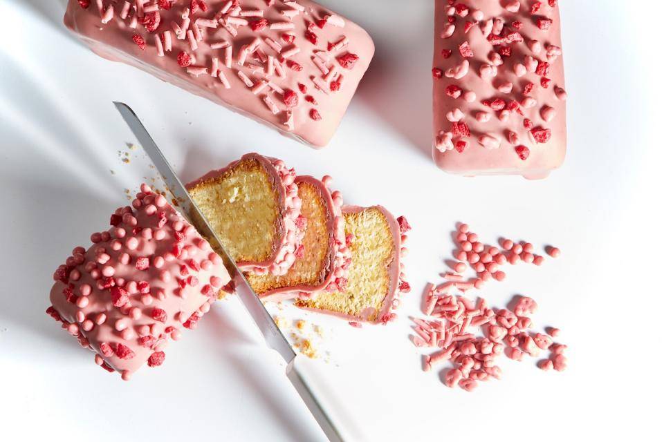 A sliced loaf of poundcake with a Ruby chocolate coating, garnished with Ruby curls and cripearls