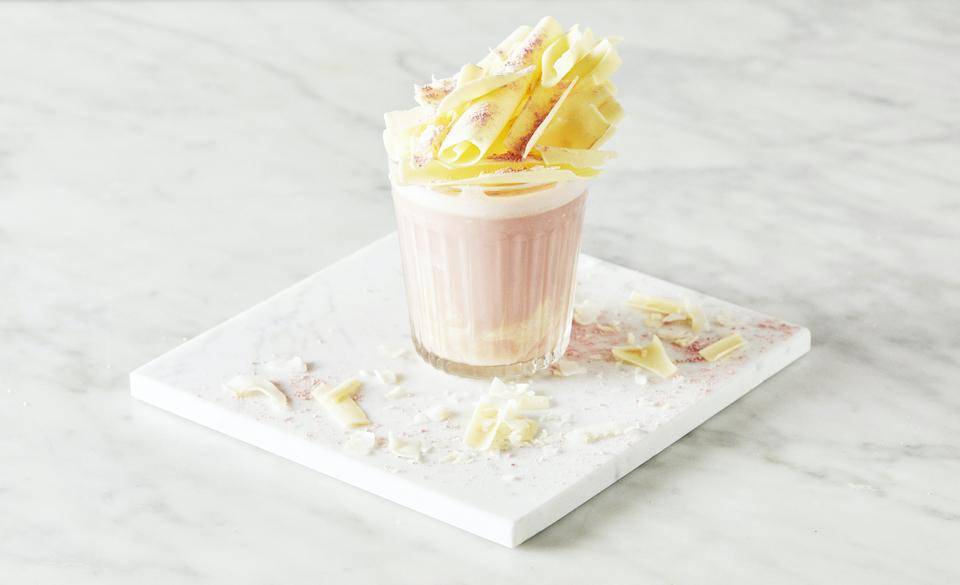 A fun Ruby Chocolate Beverage Topped with Large White Chocolate Shavings