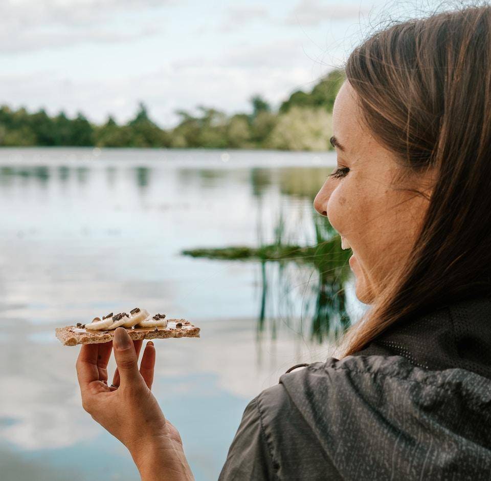 A smiling woman enjoys an al fresco snack