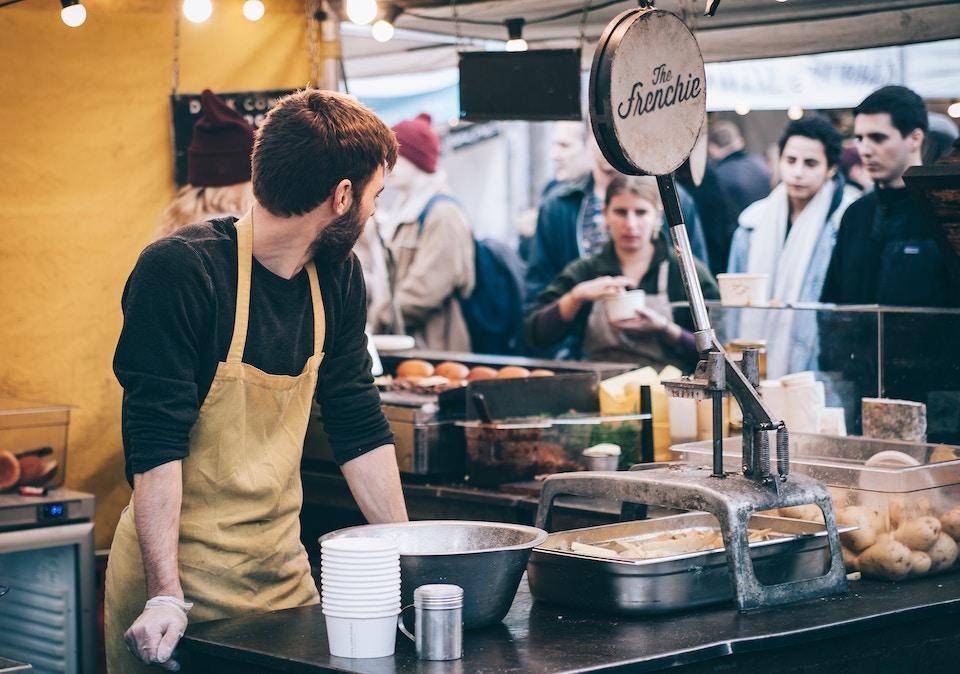 A business owner prepares to server customers at a food stall