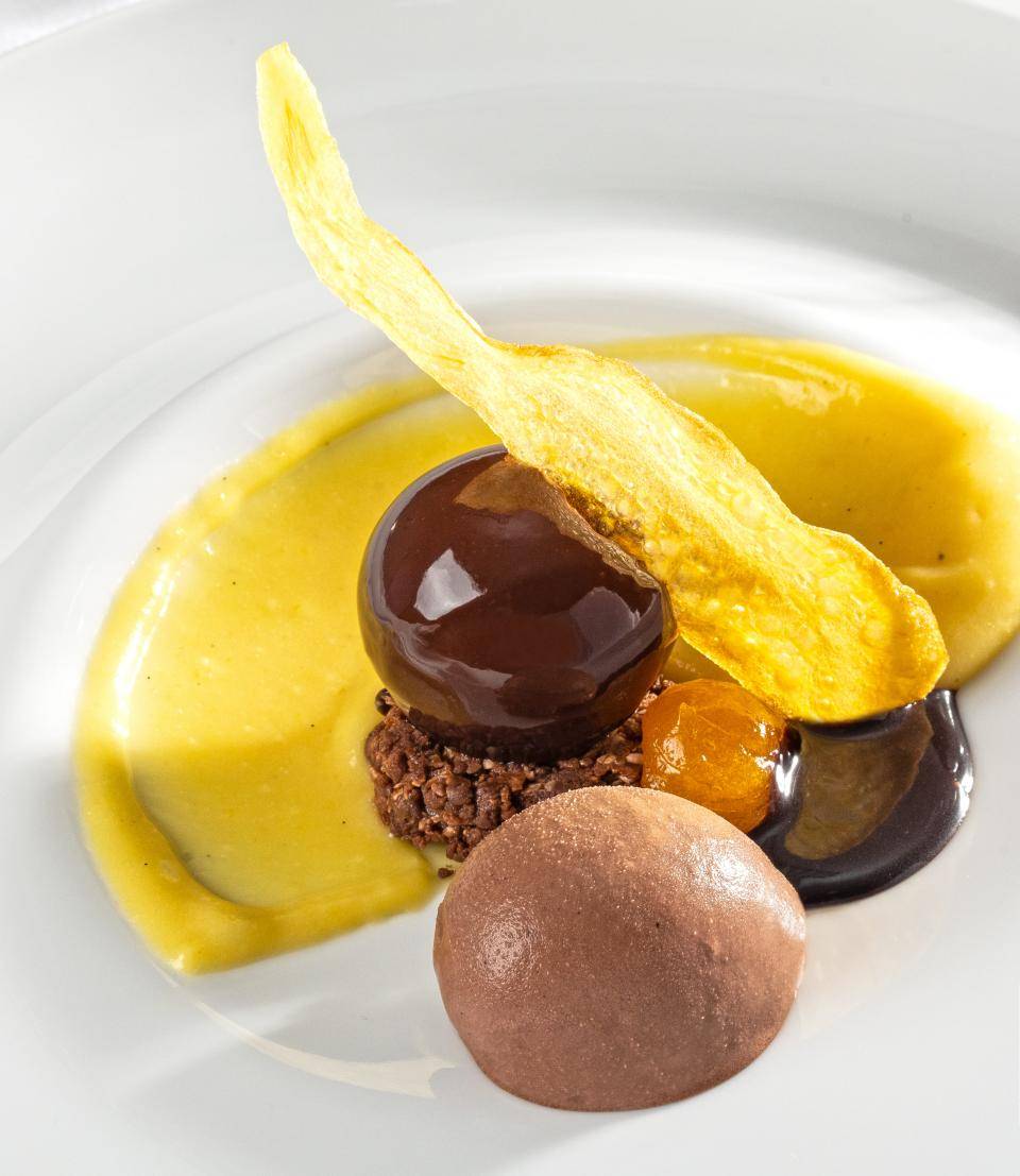 Sobremesa emprata vista de cima em sua maioria amarela e marrom de chocolate
