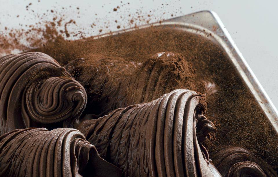 A container of attractively swirled chocolate sorbet dusted with cacao powder