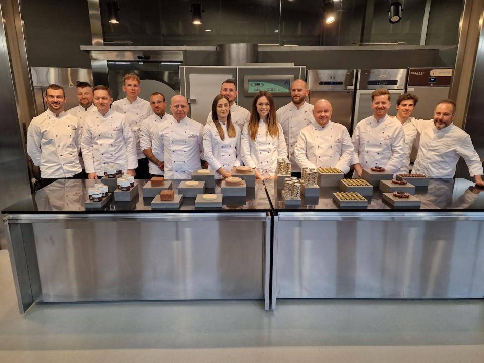 The chefs and ambassadors pose in the kitchen