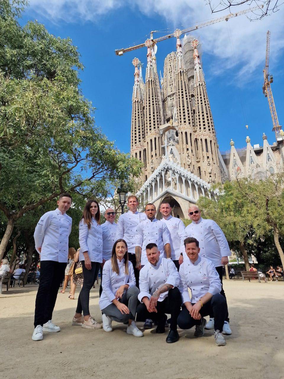 Chefs and Ambassadors from Chocolate Academy™ Poland pose for a group photo in front of a Cathedral in Barcelona