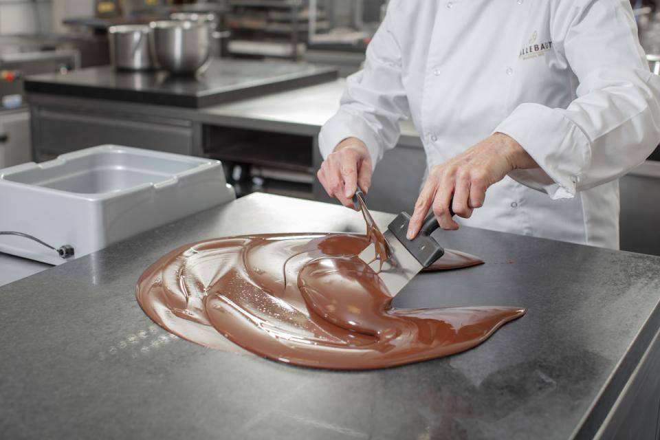 A chef tempering dark chocolate