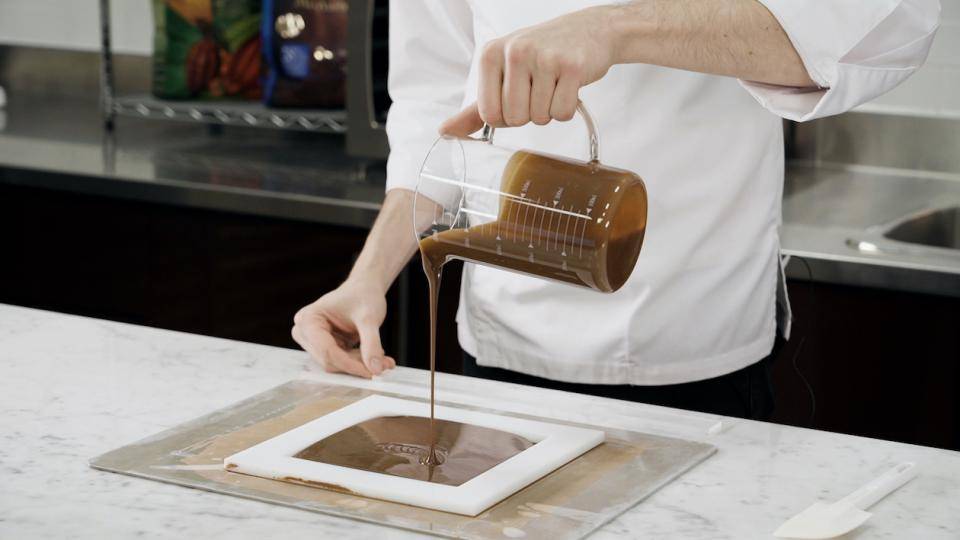 Chef Russ Thayer pours ganache into a confectionery frame