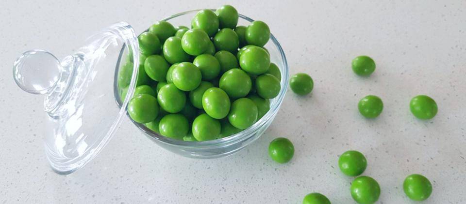 Bright green dragees in a glass bowl