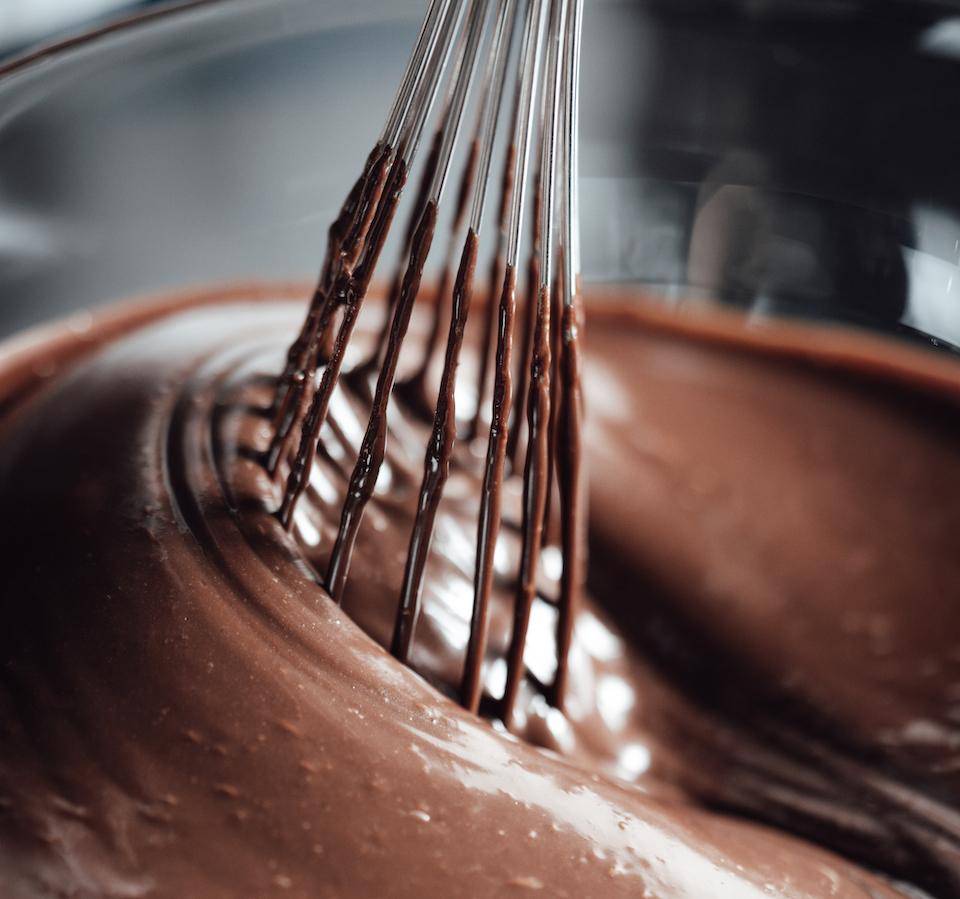 a ganache being mixed with a whisk