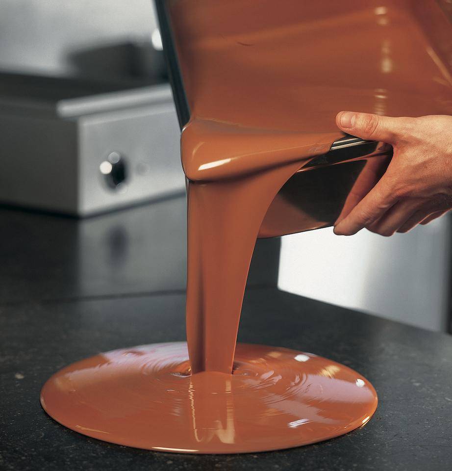 A chef pours chocolate tabletop