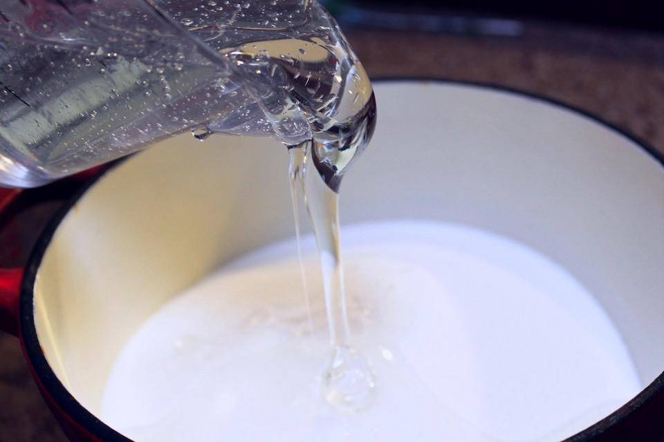 Gluose being poured on top of sugar in a bowl
