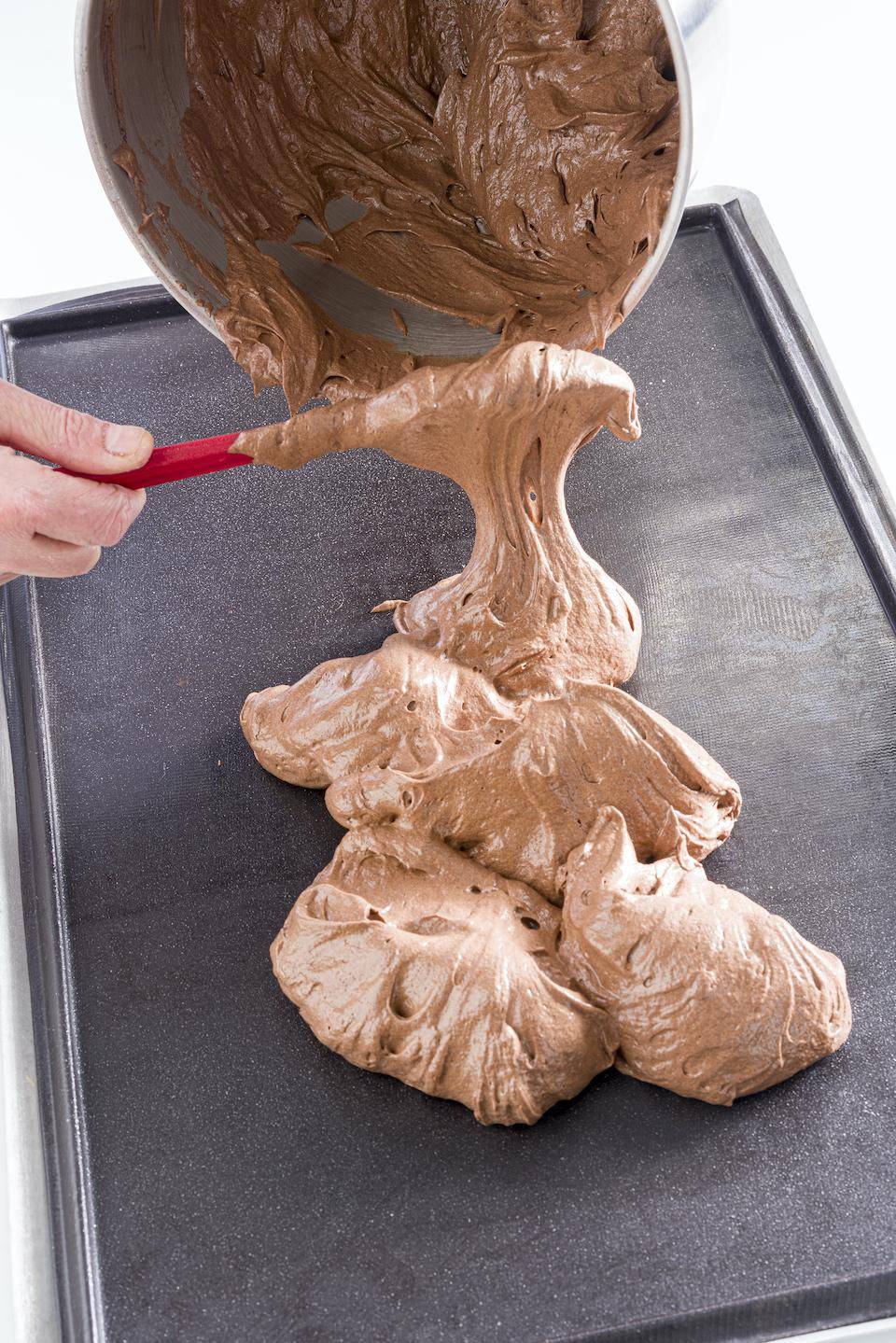 cocoa sponge batter being transferred to a silicone mold
