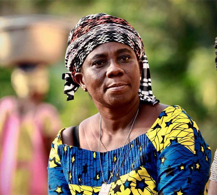 Faites connaissance avec Naomi. Cultivatrice de cacao à temps plein, femme d'affaires et maman.