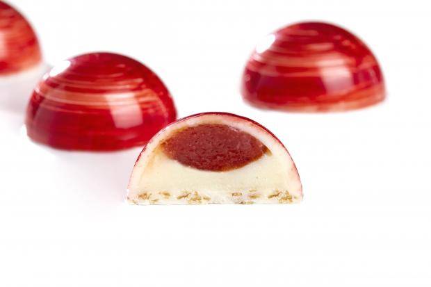 três bombons vermelhos lado a lado com um na frente cortado ao meio mostrando a goiabada e os chocolate 