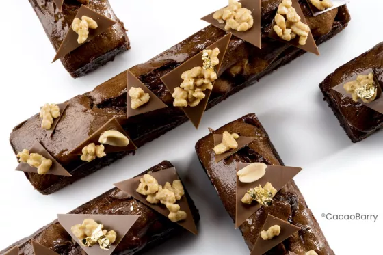 Long bars of chocolate poundcake garnished with triangles of chocolate, peanuts, and crispies