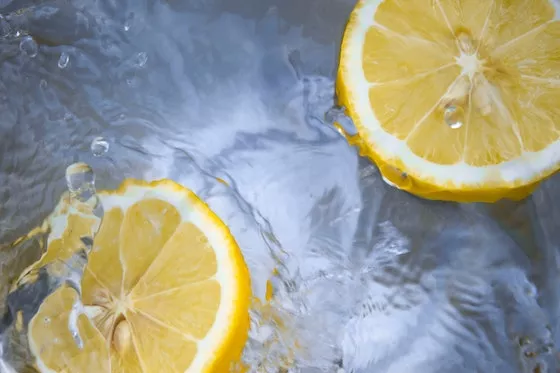 Lemon halves landing in water - splashes in lower left