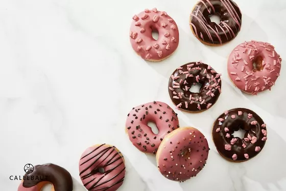 A cascade of dark and ruby chocolate-covered donuts