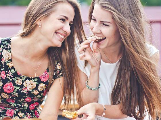 Two female friends share a chocolate moment