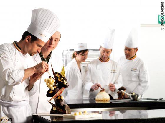 chef criando escultura de chocolate e ao fundo outros chefs observando a criação