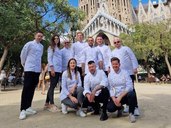 Chefs and Ambassadors from Chocolate Academy™ Poland pose for a group photo in front of a Cathedral in Barcelona