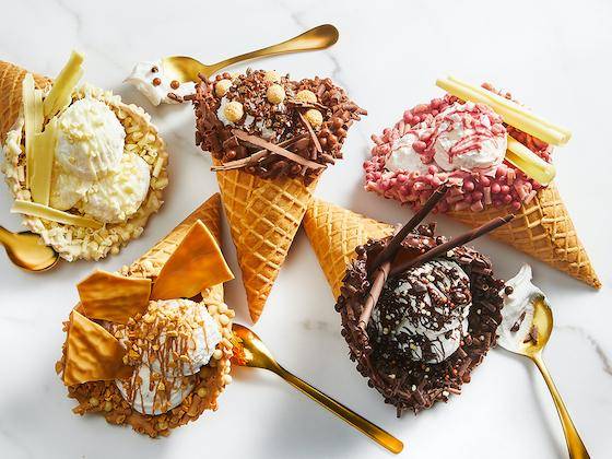 Ice cram cones each dipped in one of the 5 colors of chocolate