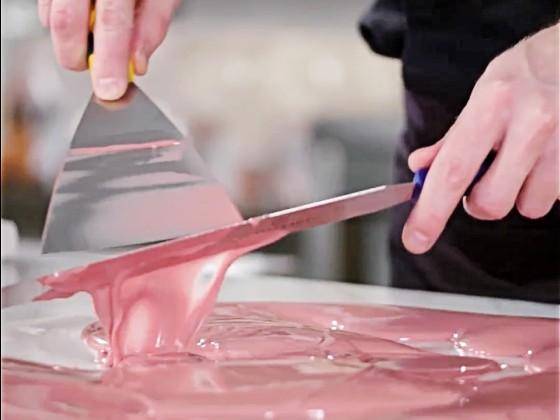 A Chef tempering Ruby Chocolate on the tabletop