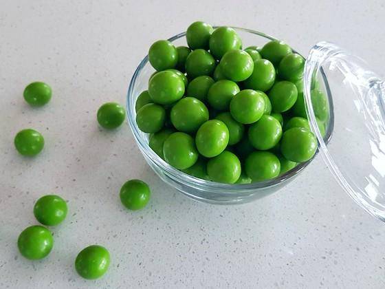 Bright green dragees in a glass bowl