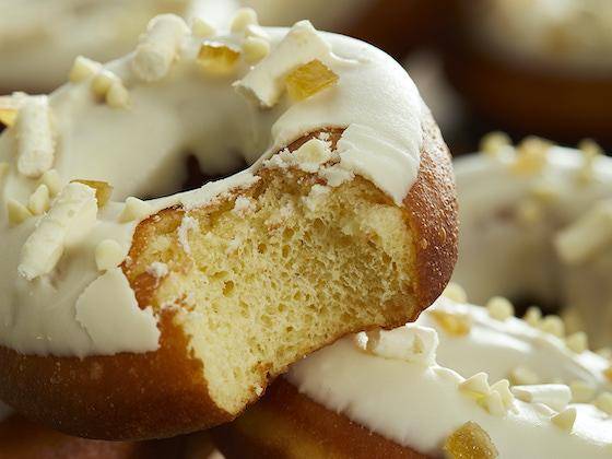 A vegan cake doughnut with white chocolate frosting and small white chocolate curls